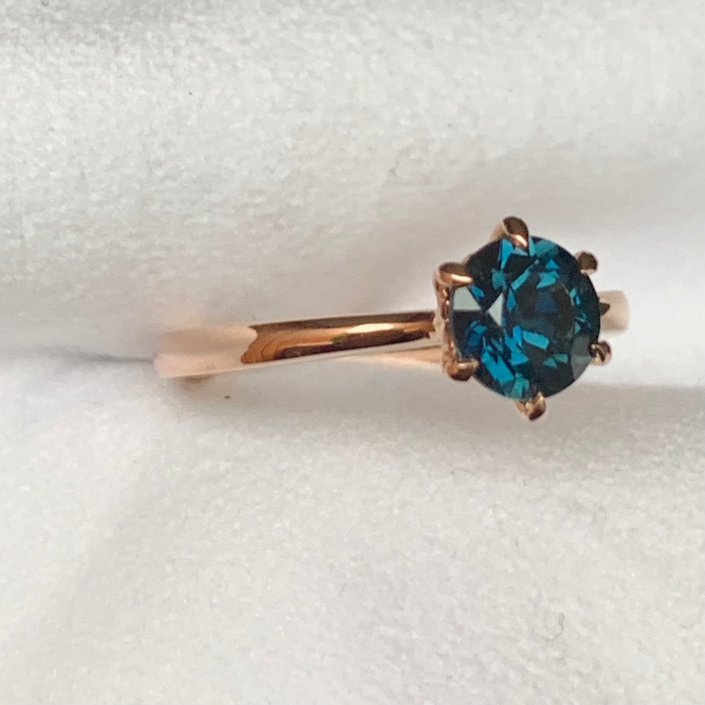 This 14ct Rose Gold Solitaire Chloe Ring is beautifully complimented by a 1.09ct teal blue Australian Sapphire, the stone is set with six eagle shaped claws in Rose gold. The Sapphire measures 6.14ct and is 1.09cts The ring is size L & can be sized to sizes I-R Made with recycled metal in Sydney Ethically sourced Gemstones